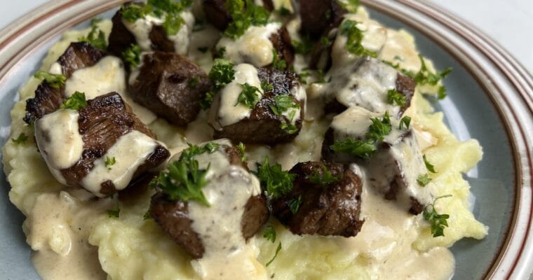 Garlic Butter Steak Bites with Creamy Parmesan Sauce over Garlic Mashed Potatoes