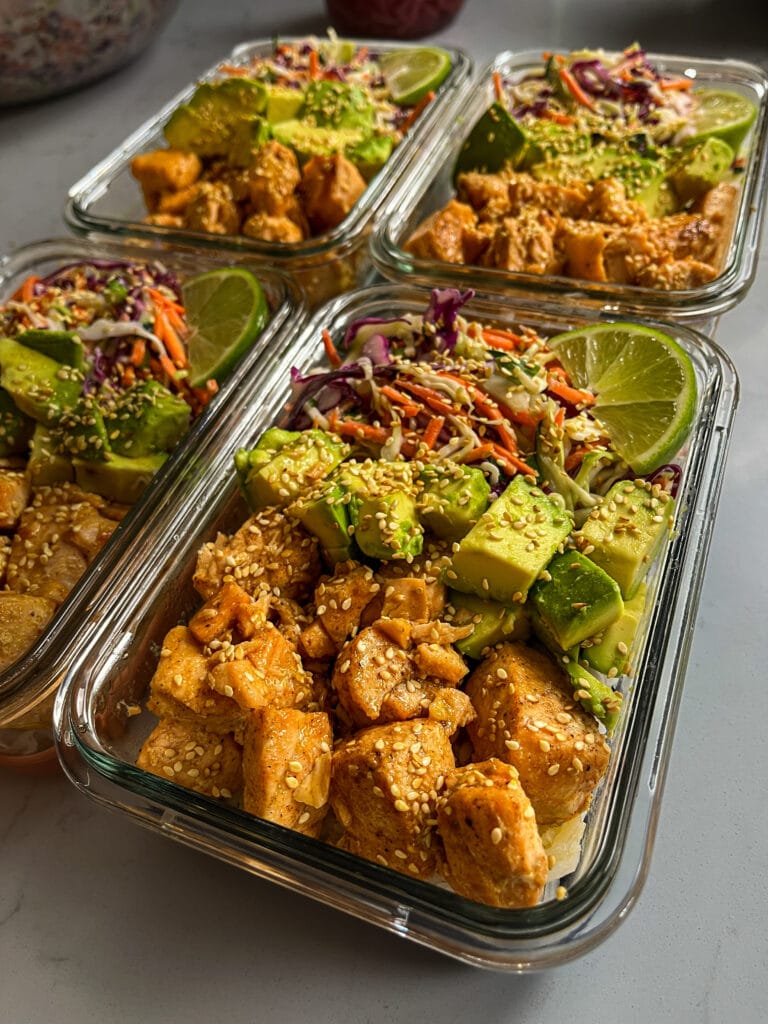 Hot Honey Salmon Bites in meal prep containers with avocado and lime slaw. 