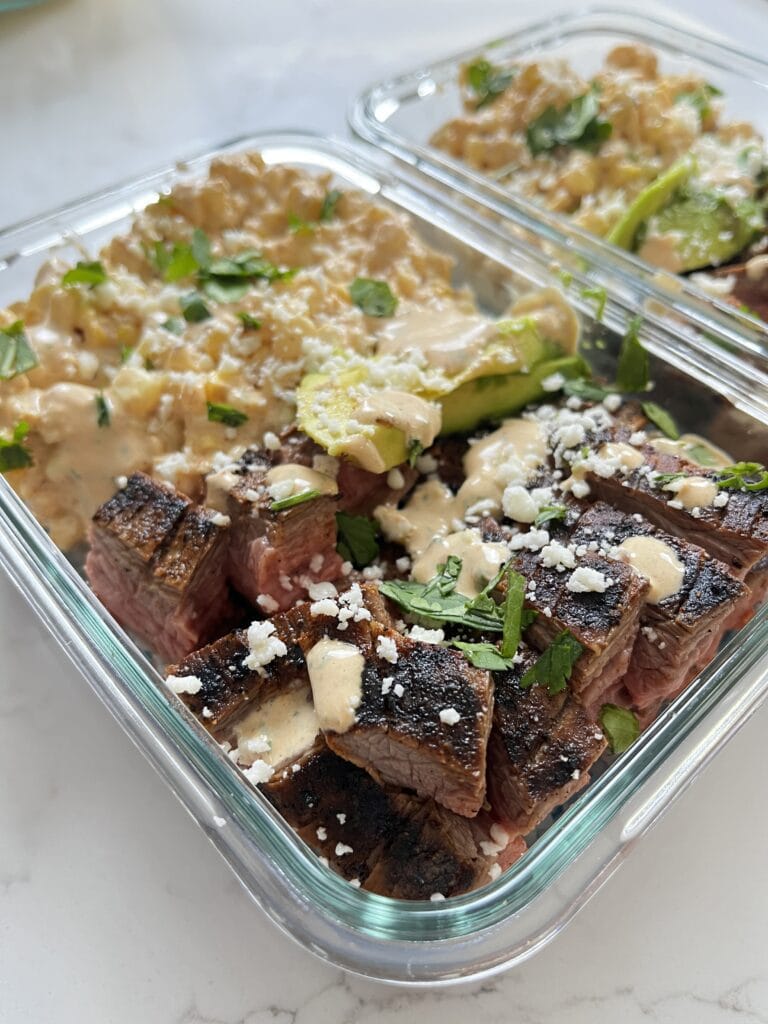 Street Corn Steak Bowls with Chipotle Lime Crema in glass meal prep bowls.