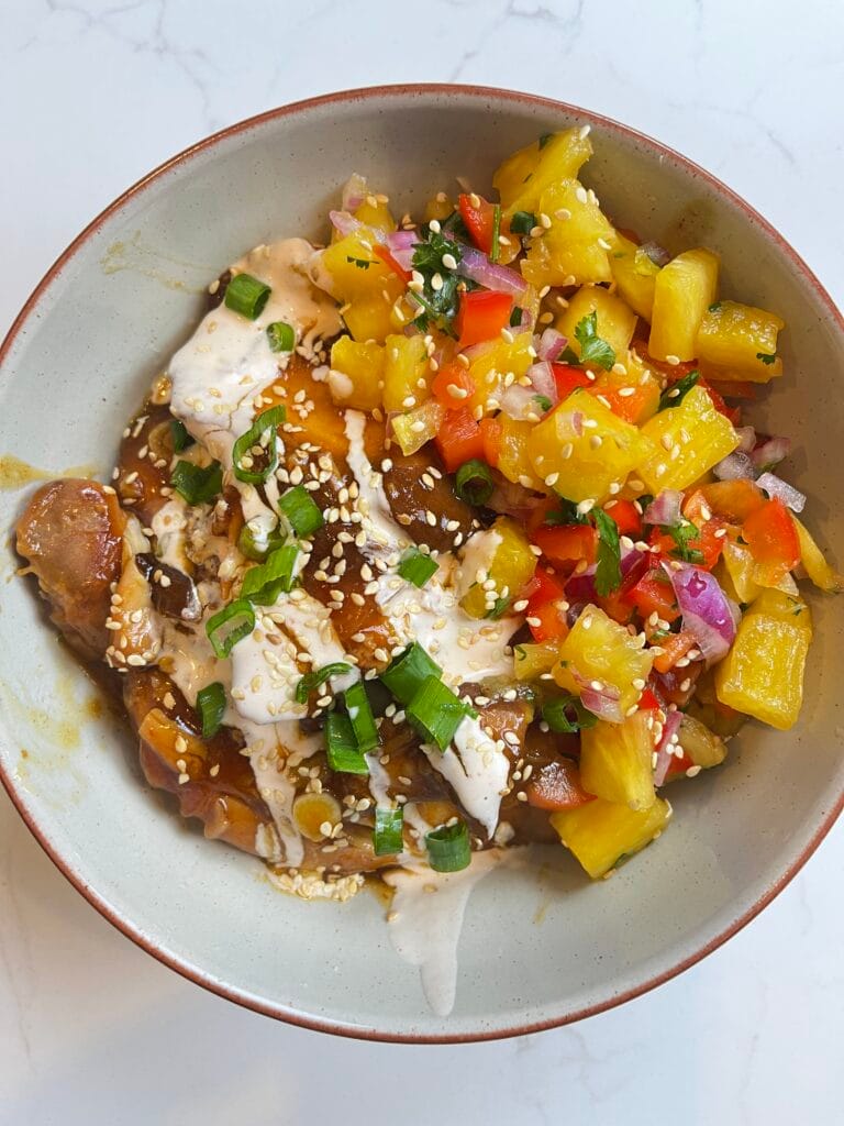 Slow Cooker Honey Garlic Pineapple in a bowl with Chili Lime Drizzle.